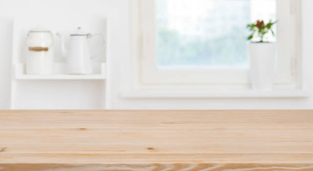 istock Wooden tabletop in front of blurred kitchen window, shelves background 1172669279