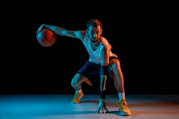 istock Young basketball player against dark background 1172679443