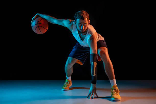 istock Young basketball player against dark background 1172679452
