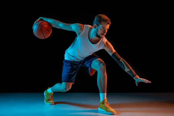 istock Young basketball player against dark background 1172679459
