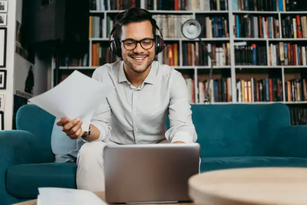 Photo of Young artist creator sitting in his studio library