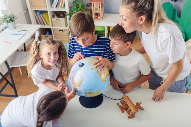 istock Teacher with School Children. Fun and Interesting Geography Lessons with School Globe. 1172681463