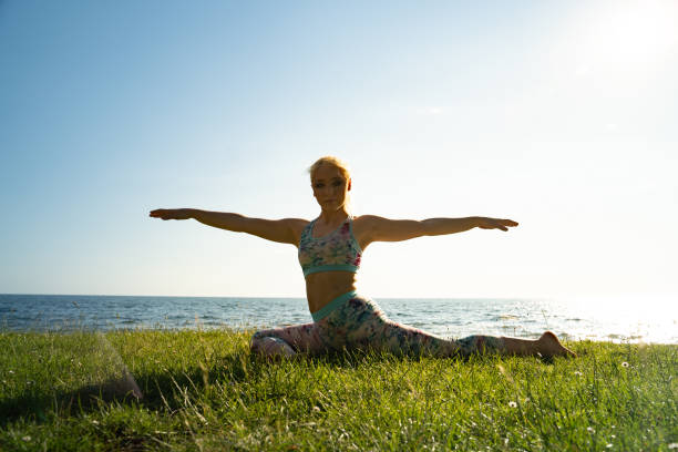 istock Young Woman Doing Yoga on Coastline 1172682767