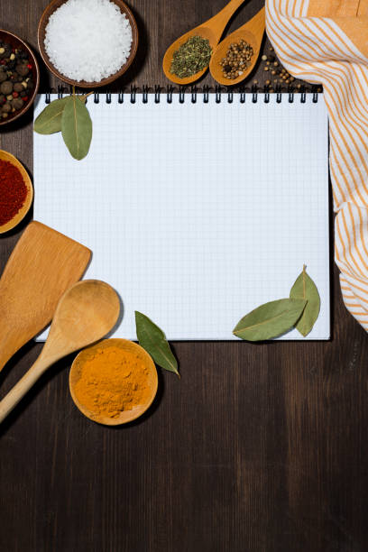 istock open notebook for writing recipes, kitchen spoons and spices wooden background concept, vertical 1172683213