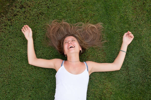 istock Happy young woman laying on the grass 1172683285