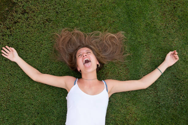 istock Happy young woman laying on the grass 1172683302