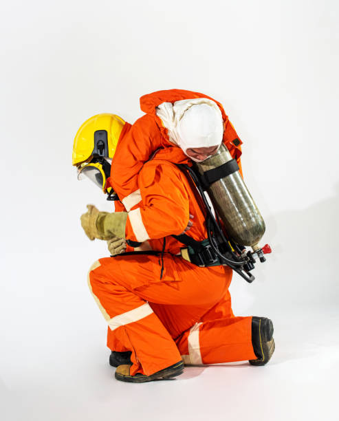 istock Selective focus wide shot firefighter in fire suit carrying unconscious man on his shoulders in first aid emergency training class isolated white background. Safety, rescue and health care concept. 1172687364