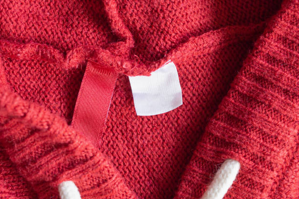 istock Blank white laundry care clothing label on red knitted texture background 1172688575