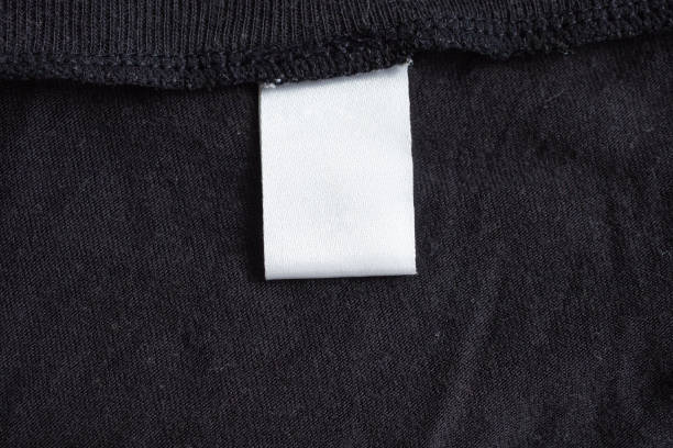 istock Blank white laundry care clothing label on black fabric texture 1172688578