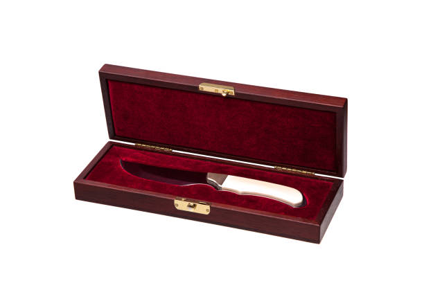 istock A hunting knife with an ivory handle in a gift wooden case isolate on a white background. Beautiful gift weapon on red velvet in a wooden casket. 1172690939