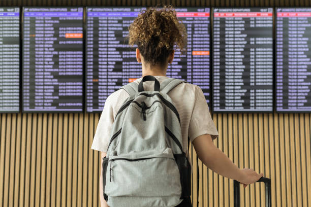 istock Young woman traveler looking at flight information 1172692202