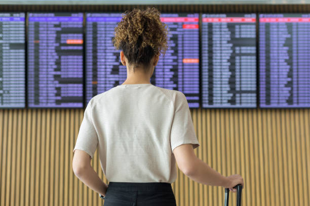 joven viajera mirando información de vuelo - commercial airplane airport arrival departure board business travel fotografías e imágenes de stock