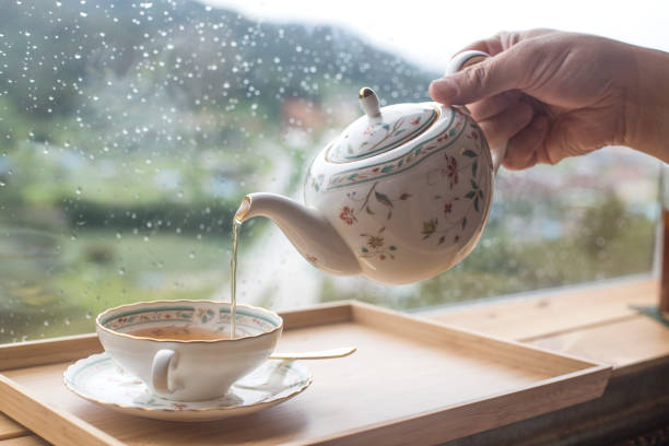istock A man pouring black tea from the ceramic teapot in cafe. Close up on hands 1172701434