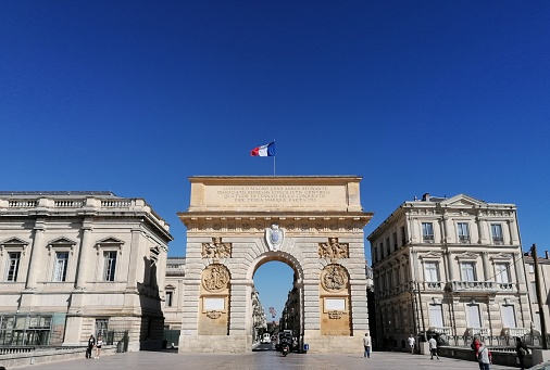 Old monument located in Southern France and other old buildings with tourists