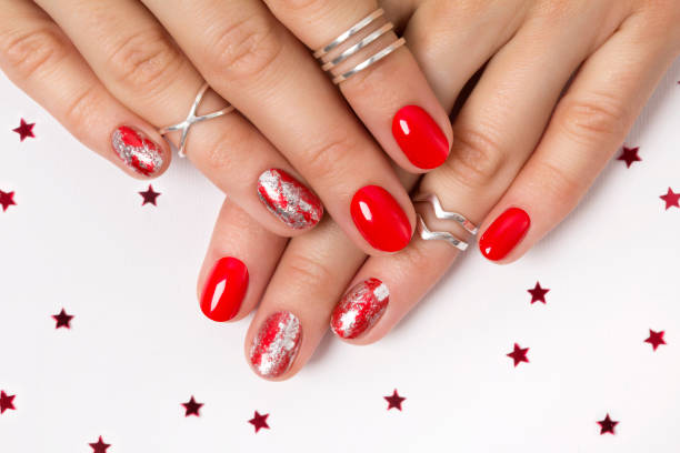 Beautiful manicured woman's hands over white background with confetti Christmas New Year manicure abstract nail design. Beautiful manicured woman's hands over white background with confetti christmas nails stock pictures, royalty-free photos & images