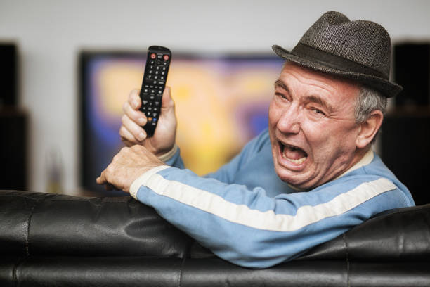 istock Senior man having trouble with remote control as he watches TV 1172707615