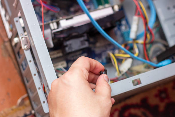 The young technician hold the cord for repairing the computer in his hand. Computer hardware, service, upgrade and technology repairing concept