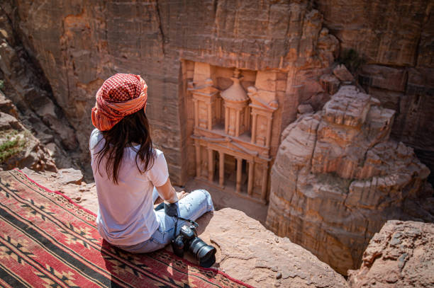 viaggiatrice asiatica seduta a petra, giordania - amman foto e immagini stock