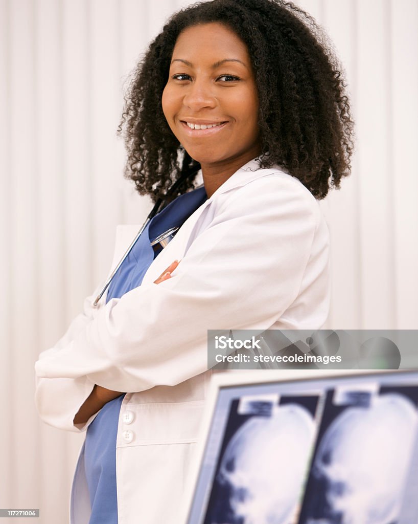 Portrait du docteur à côté de ordinateur écran avec xray - Photo de Blouse de laborantin libre de droits