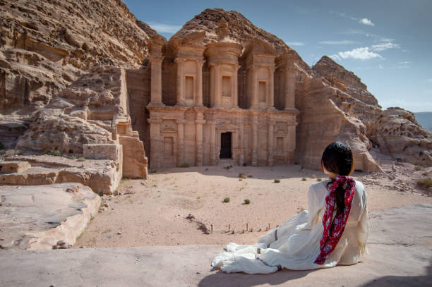 mujer asiática turista sentada en petra, jordania - petra antiquities jordan middle east fotografías e imágenes de stock