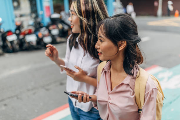 istock Women students on the street downtown using smart phones 1172714331