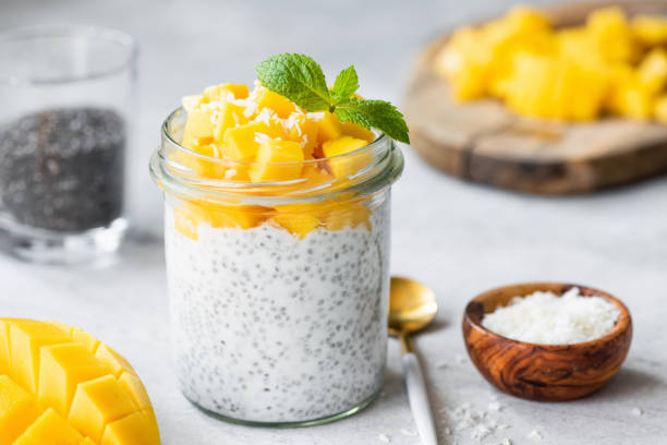 Chia seed pudding with mango cubes and coconut Chia seed pudding with mango cubes and coconut in glass jar. Closeup view. Vegan vegetarian food, clean eating concept chia seed stock pictures, royalty-free photos & images