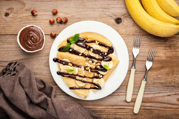 crepes mit bananen- und schokoladensauce - pancake blini russian cuisine french cuisine stock-fotos und bilder