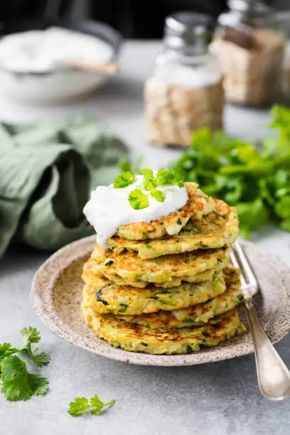 Zucchini quinoa fritters with sour cream. Vegetable pancakes ready for eating. Healthy vegetarian food