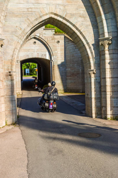 Motorcycles driving into a archway