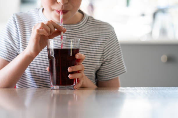 Close Up Of Girl Drinking Sugary Fizzy Soda From Glass With Straw Close Up Of Girl Drinking Sugary Fizzy Soda From Glass With Straw soda photos stock pictures, royalty-free photos & images