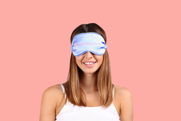 istock Smiling woman wearing blue sleeping patch on pink background. 1172723617
