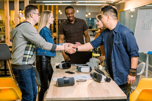 istock Team of developers working with virtual reality glasses during a business meeting. Young business colleagues brainstorming, hand shaking at the meeting in modern office room. 1172723761