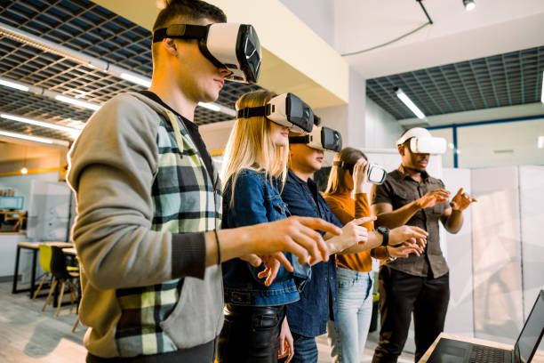 istock Five multiethnical excited smiling businesspeople wearing virtual reality glasses, interacting with digital interface while standing near table in modern office 1172723777