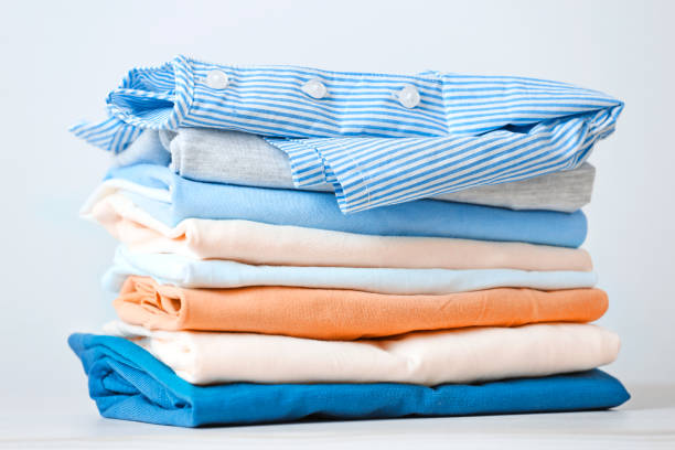 stack of colorful cotton clothes. heap of   folded laundry. - monte roupa imagens e fotografias de stock