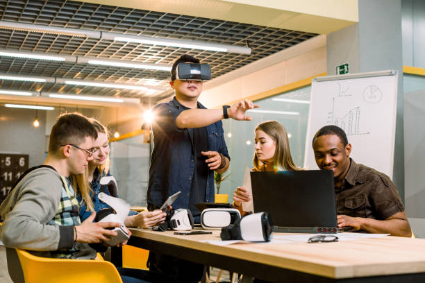 istock Business team of young multiethnical people presenting new project to a client on a virtual reality simulator. Young Chinese man the client with VR glasses 1172723896