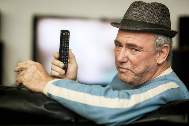 istock Senior man having problems with remote control as he watches TV 1172723900