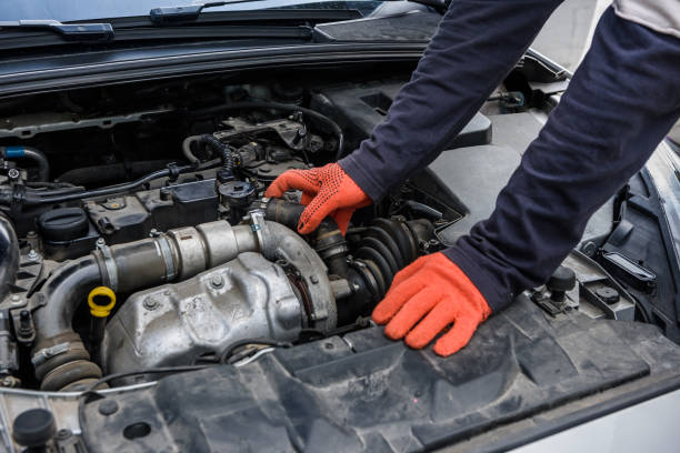 istock Mechanic examining car engine under hood close up 1172724044