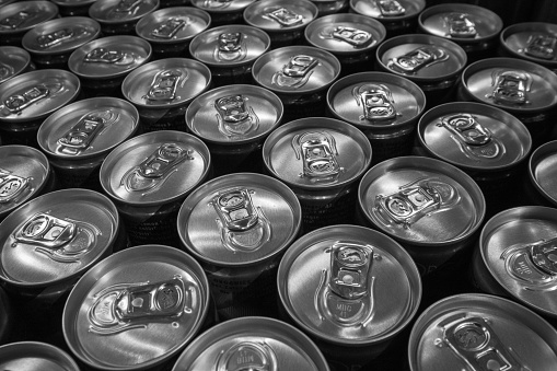 Packaging drinks in aluminum cans in a store, close-up, top view