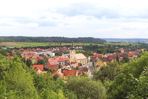 beautiful panoramic view to a Bavarian village in green summer surrounding, framed with trees, background with copy space