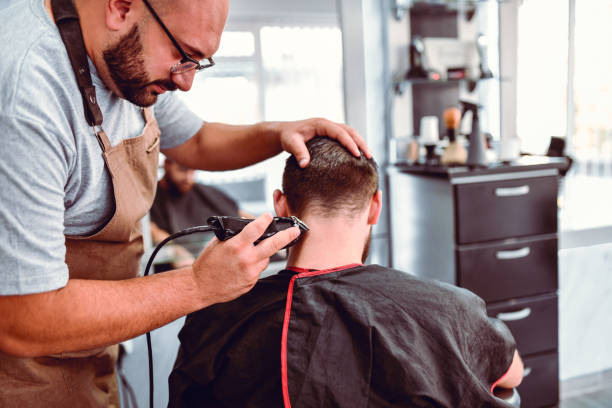 istock Barber Using Electric Clipper To Trim Customer's Hair 1172726794