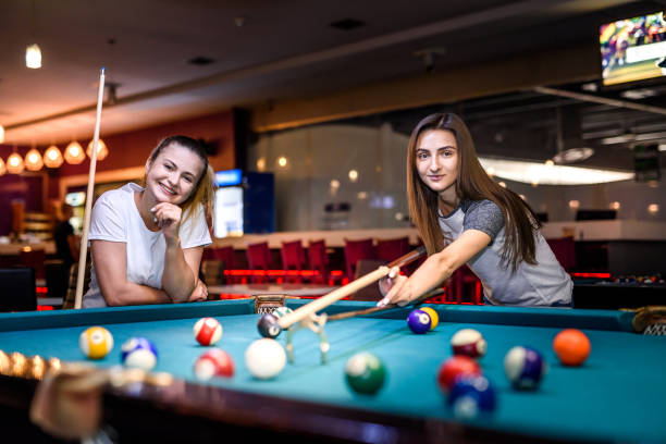 istock Happy and excited women playing billiard together 1172726841