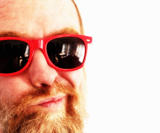 istock Bearded middle-aged man in red sunglasses looks doubtful or suspicious 1172729229