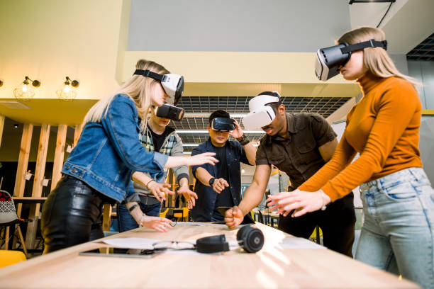 istock Business people using virtual reality goggles during meeting. Team of multiethnical developers testing virtual reality headset and discussing new ideas to improve the visual experience. 1172731998