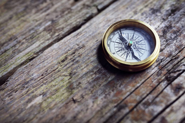 antique golden compass on wood background - compass direction antique guidance imagens e fotografias de stock