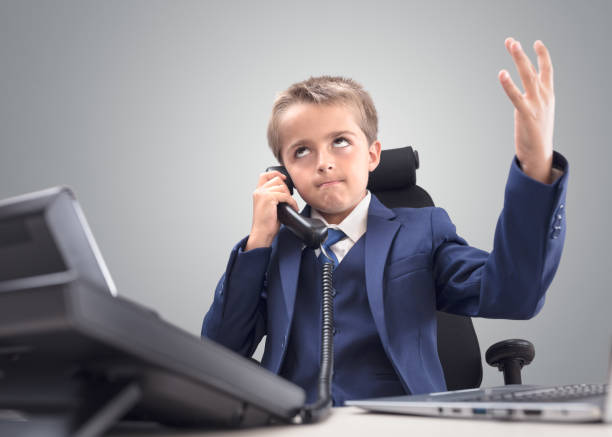 Frustrated young child businessman despair and disappointment on the telephone Frustrated and stressed young child businessman despair and disappointment on the telephone rolling eyes irritation displeased facial expression stock pictures, royalty-free photos & images