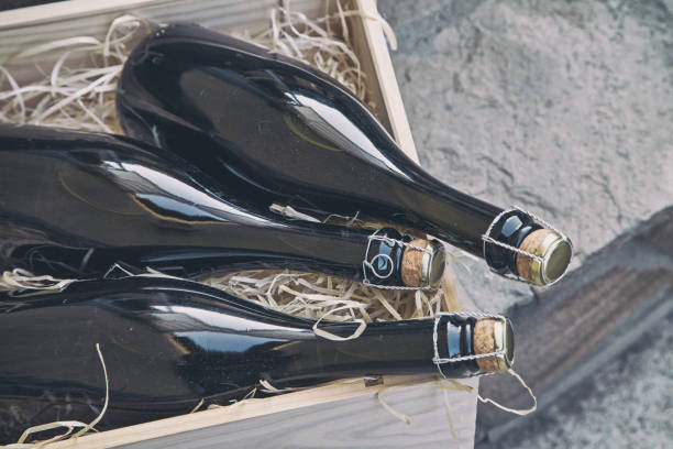 istock three champagne bottles in a wooden box on a stone wall background 1172736922