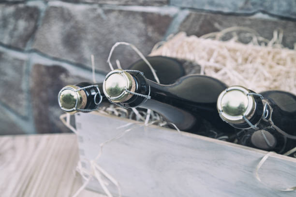 istock three champagne bottles in a wooden box on a stone wall background 1172736981