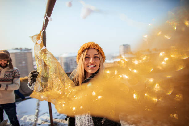 Young woman decorating rooftop terrace for a New Year's Eve celebration