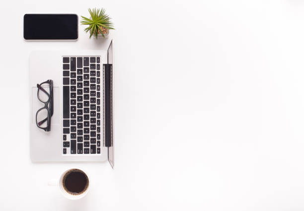 Top view of ordered desktop with laptop, coffee and cellphone