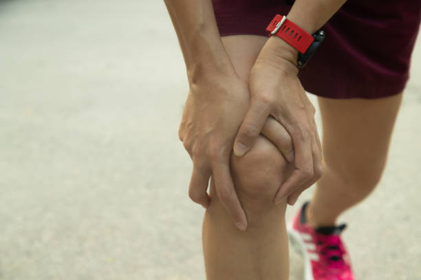 istock woman use hands hold on her knee injury while running. 1172740191